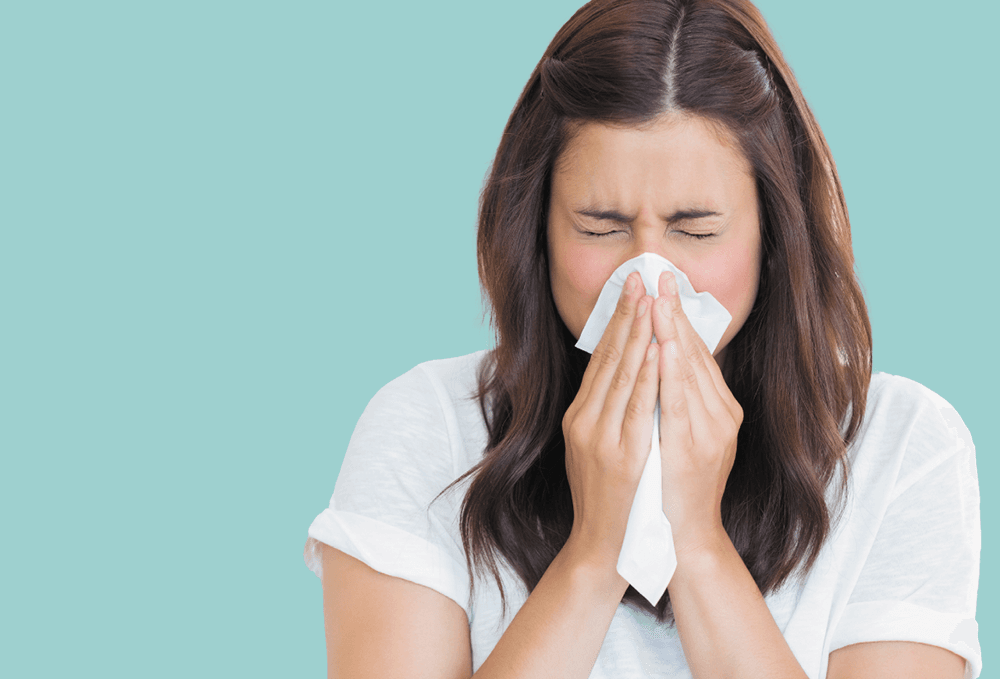 Woman blower her nose with a tissue